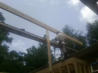 Carpenter setting a ridge beam over a new addition frame — Ice Dam Removal by Roofing Brothers in Goleta