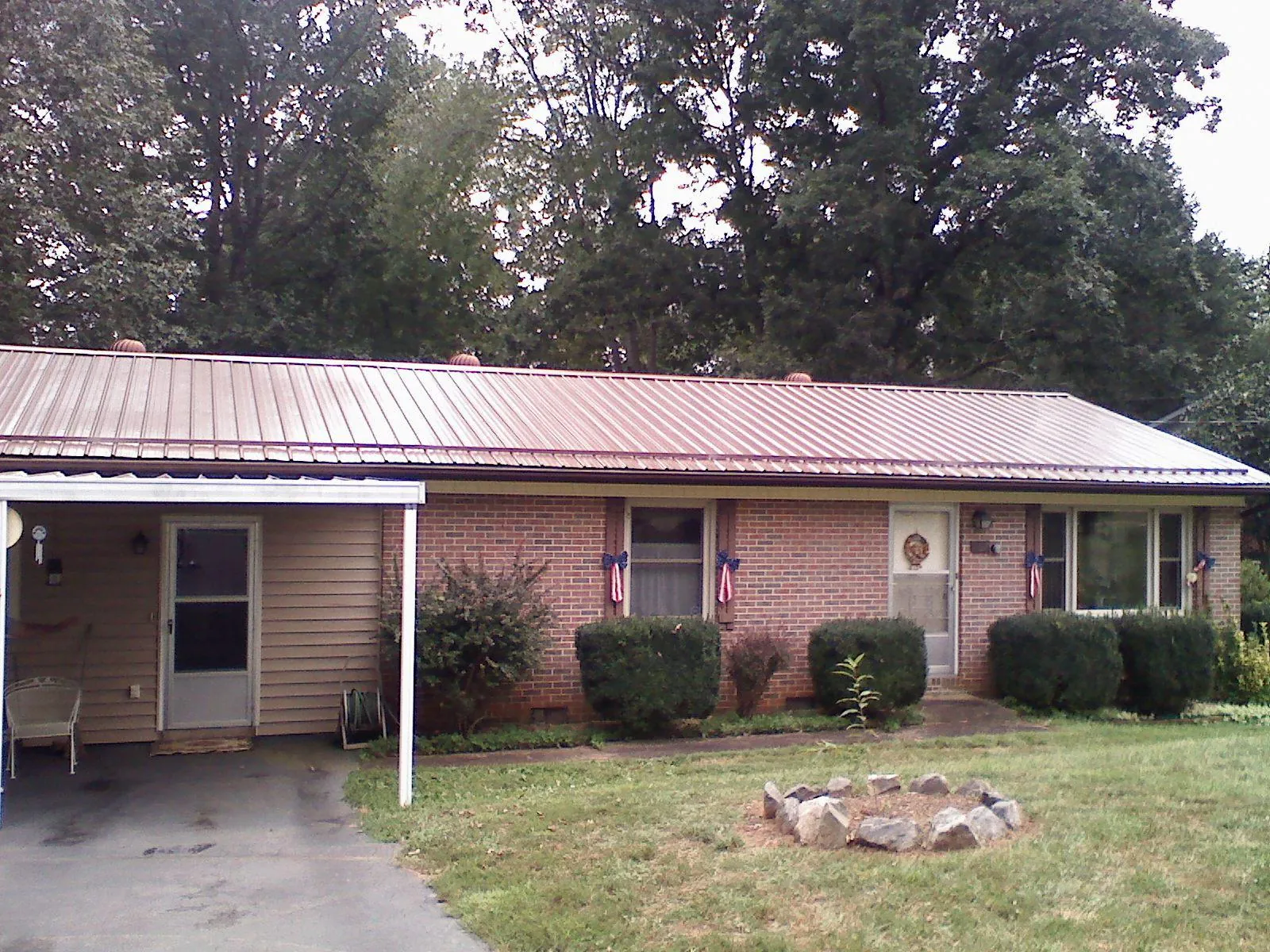 Bronze metal roof and carport on a brick ranch home — Roof Repair work by our crew in Goleta